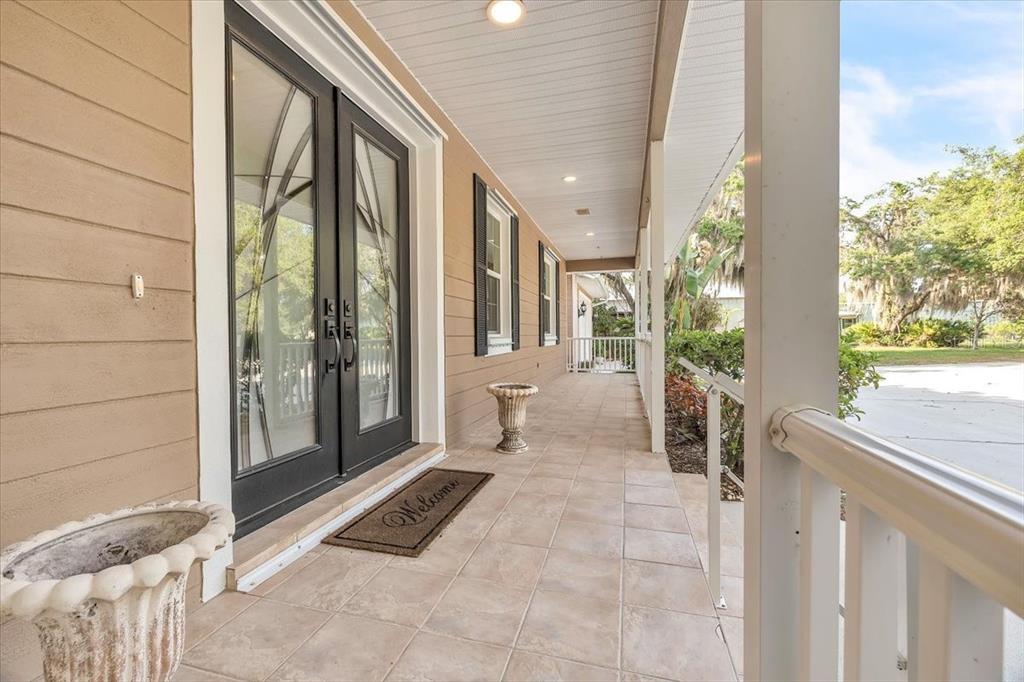 10597 Southwest Kissimmee Road Arcadia, FL 34269 - Photo 5 of 54 a porch with a bench and potted plants