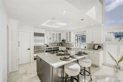 a kitchen with stainless steel appliances kitchen island granite countertop a sink and cabinets