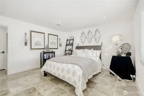 a bedroom with a bed and a lamp on dresser