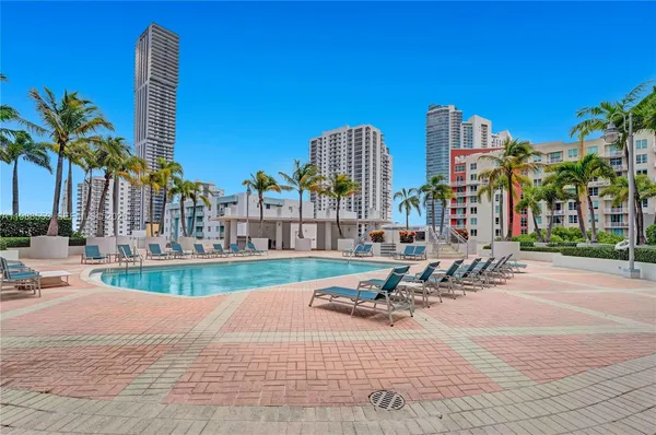 a row of palm trees and building in the background
