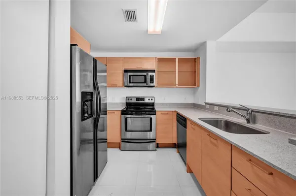 a kitchen with stainless steel appliances granite countertop a refrigerator and a sink