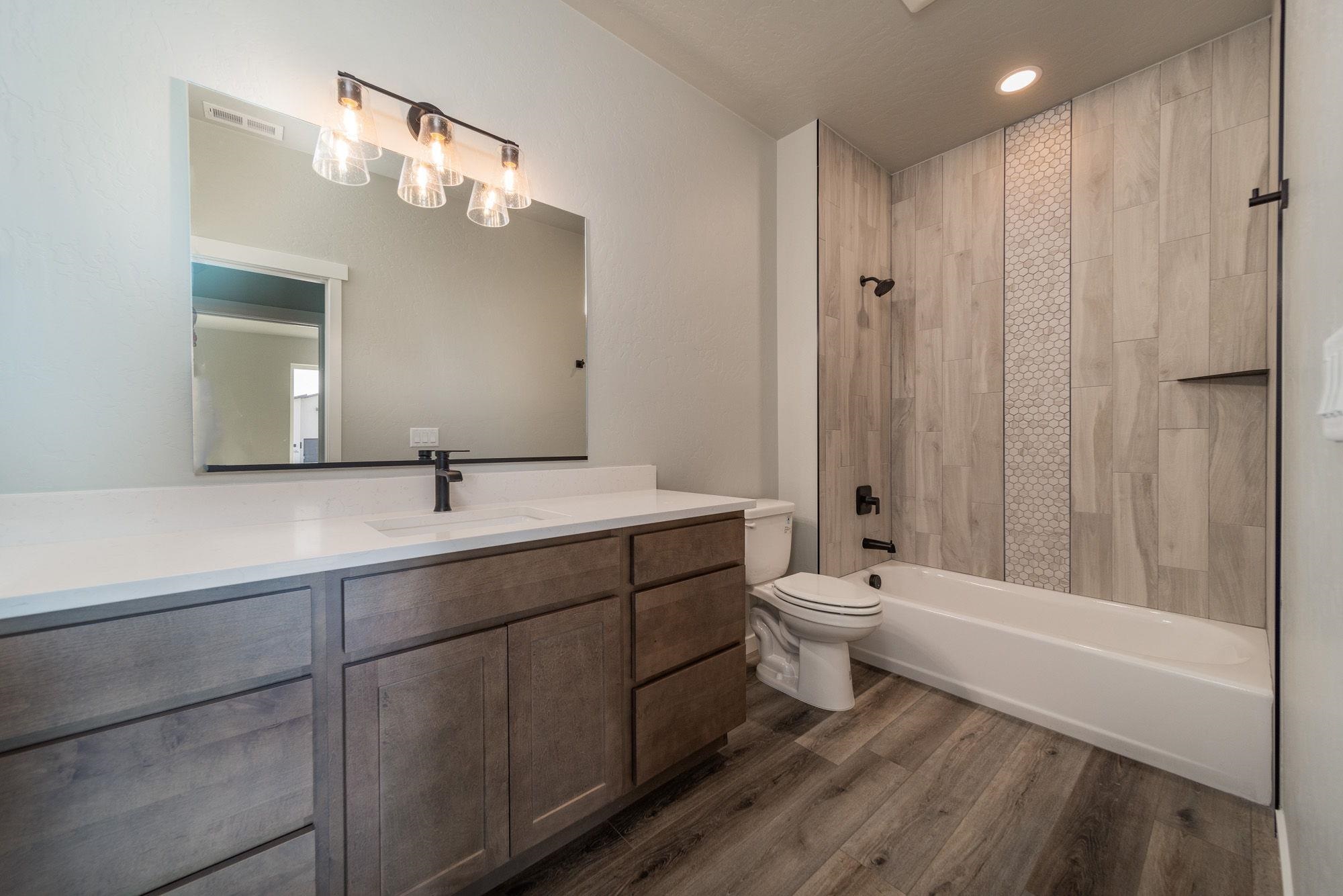 1614 Tungsten Way Fruita, CO 81521 - Photo 15 of 16 a bathroom with a double vanity sink toilet mirror and bathtub