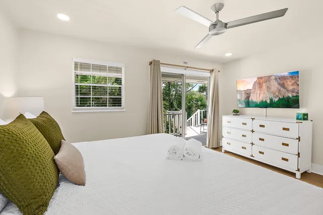 a bedroom with a bed dresser and window