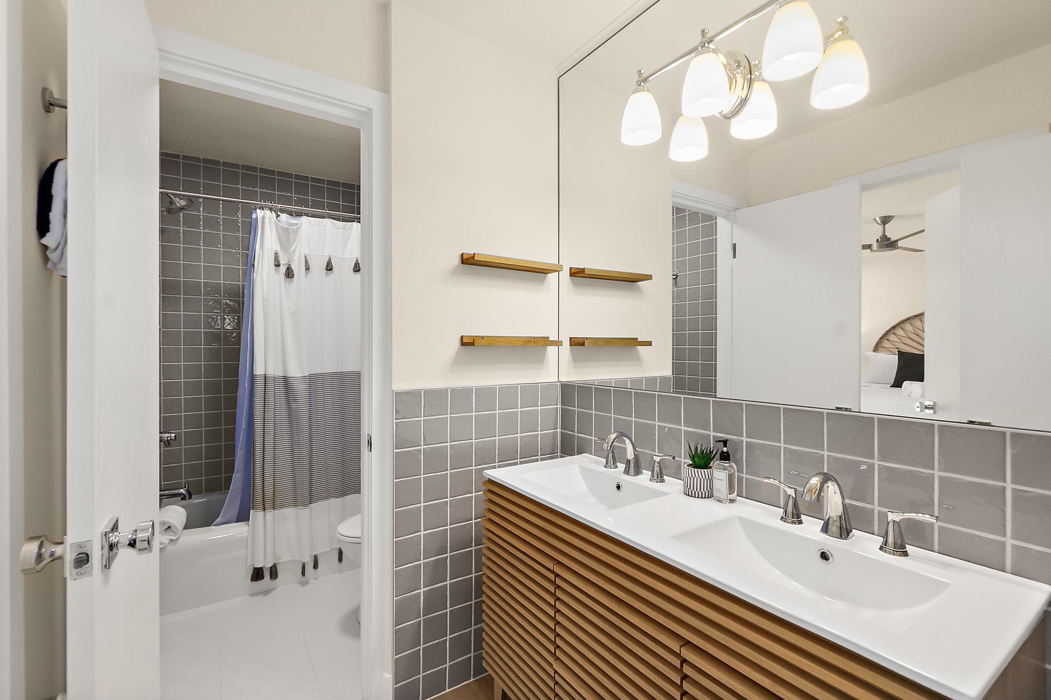 405 Flagler Boulevard, Unit 8A St. Augustine, FL 32080 - Photo 20 of 35 a bathroom with a sink a double vanity and a mirror