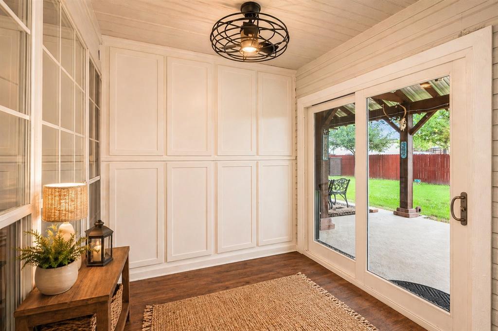 1401 Hickory Drive Pilot Point, TX 76258 - Photo 17 of 34 Built-in white paneled storage cabinetry paired with extensive glass pane windows and a sliding glass door to a covered patio
