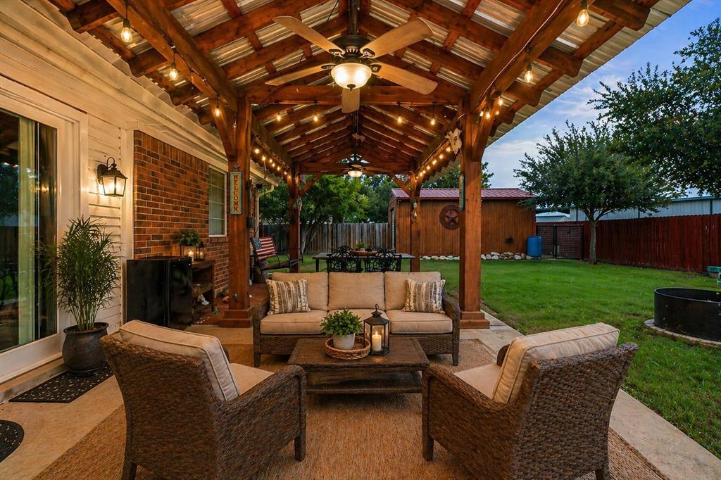 1401 Hickory Drive Pilot Point, TX 76258 - Photo 18 of 34 Expansive covered patio featuring a corrugated metal roof, exposed wood beams, and string lighting