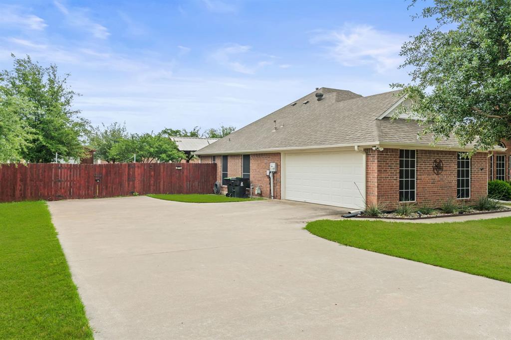 1401 Hickory Drive Pilot Point, TX 76258 - Photo 25 of 34 Brick exterior residence featuring a two-car garage, concrete driveway, and a shingle roof