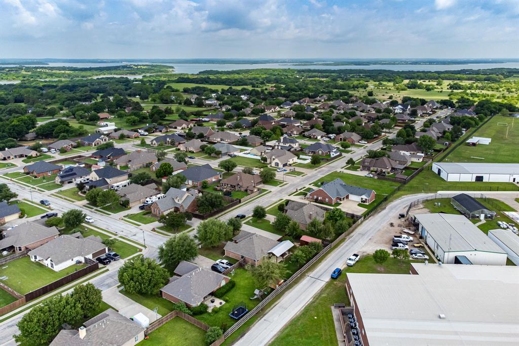 1401 Hickory Drive Pilot Point, TX 76258 - Photo 33 of 34 Aerial perspective showcasing a residential neighborhood with a variety of single-story homes, green landscaping, and paved streets