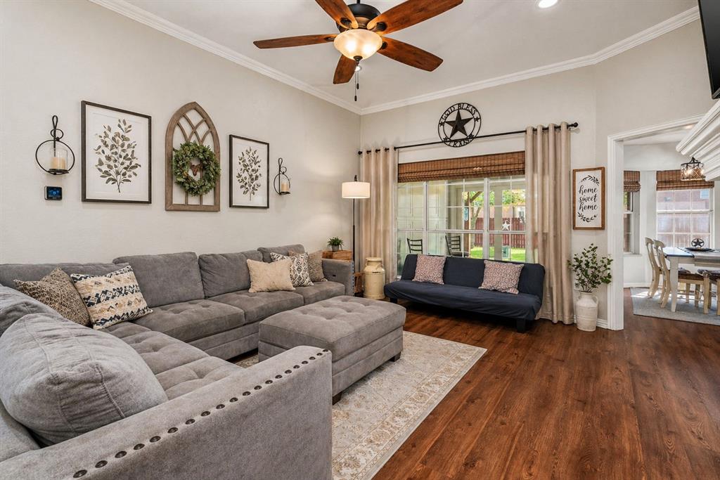 1401 Hickory Drive Pilot Point, TX 76258 - Photo 3 of 34 Spacious living area featuring wood-finish flooring, a ceiling fan with integrated lighting, and crown molding