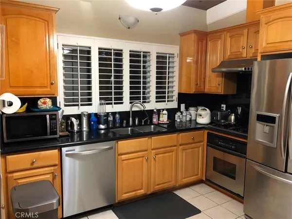 a kitchen with granite countertop a sink stainless steel appliances and cabinets
