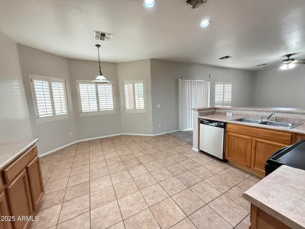 a kitchen with stainless steel appliances granite countertop a stove a sink dishwasher a refrigerator and white cabinets with wooden floor