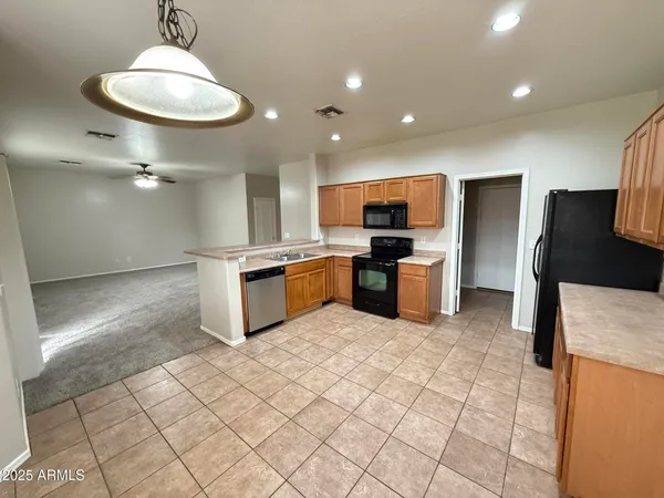 a kitchen with stainless steel appliances granite countertop a sink a stove a refrigerator and a granite counter tops