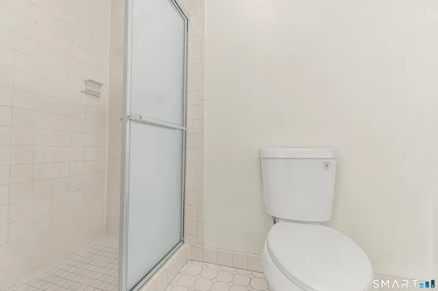 a white toilet sitting next to a white wall