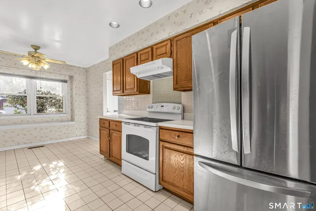 a kitchen with stainless steel appliances granite countertop a refrigerator and a stove
