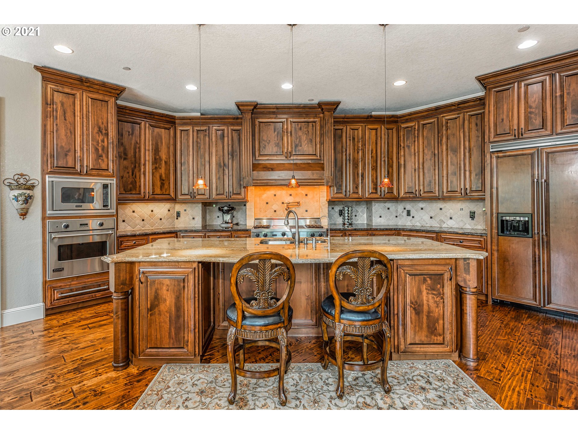 24814 Northwest 4th Court Ridgefield, WA 98642 - Photo 8 of 29 a kitchen with kitchen island granite countertop wooden cabinets and stainless steel appliances