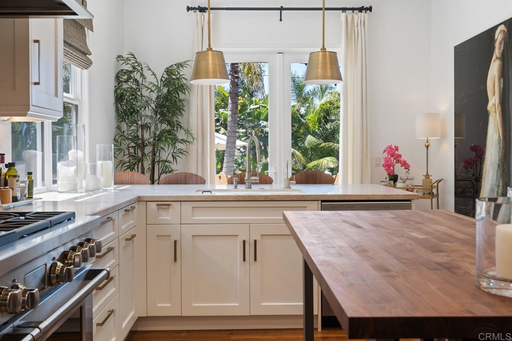 1068 Devonshire Drive Encinitas, CA 92024 - Photo 24 of 44 a kitchen with kitchen island granite countertop a stove and a white cabinets