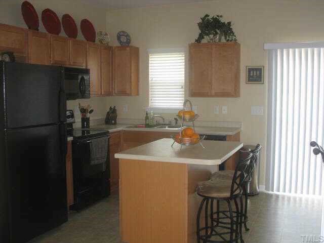 2224 Persimmon Ridge Drive Raleigh, NC 27604 - Photo 3 of 10 a kitchen with a sink a refrigerator and a window