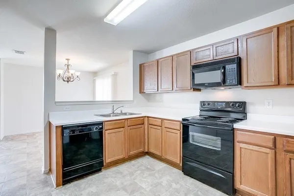 a kitchen with granite countertop a stove top oven microwave and cabinets