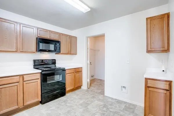 a kitchen with cabinets stainless steel appliances and wooden floor