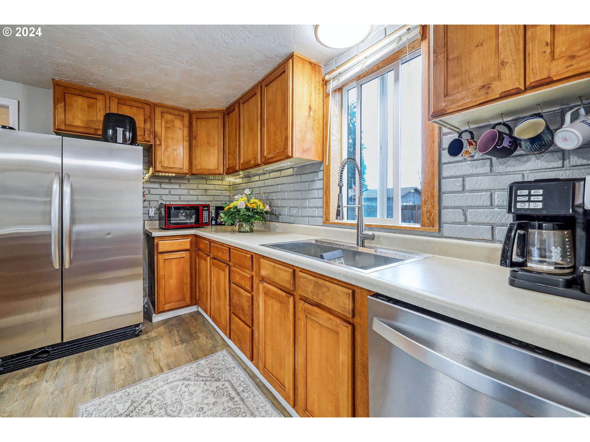 615 48th Street Springfield, OR 97478 - Photo 7 of 16 a kitchen with stainless steel appliances granite countertop a sink a stove and a refrigerator