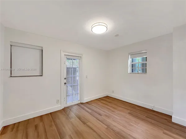 a view of a room with wooden floor and window