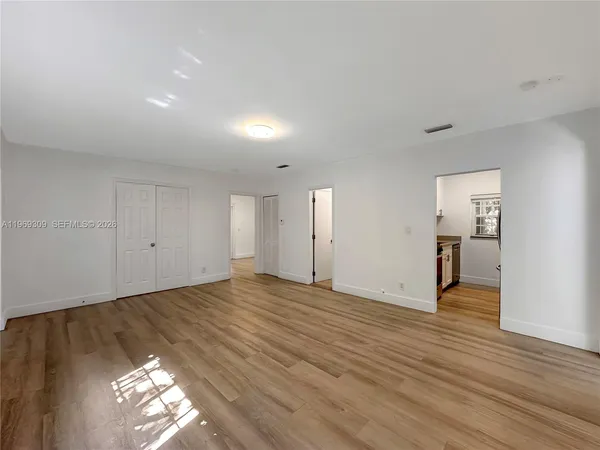 a view of empty room with wooden floor