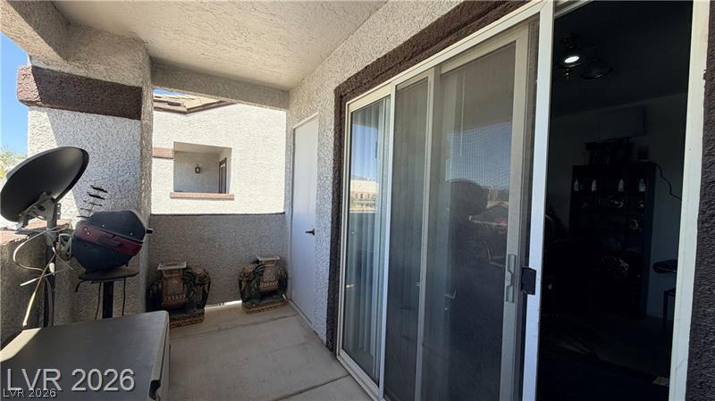 7255 West Sunset Road, Unit 2027 Las Vegas, NV 89113 - Photo 21 of 38 Sliding glass doors open directly to a private covered balcony with textured stucco walls.
