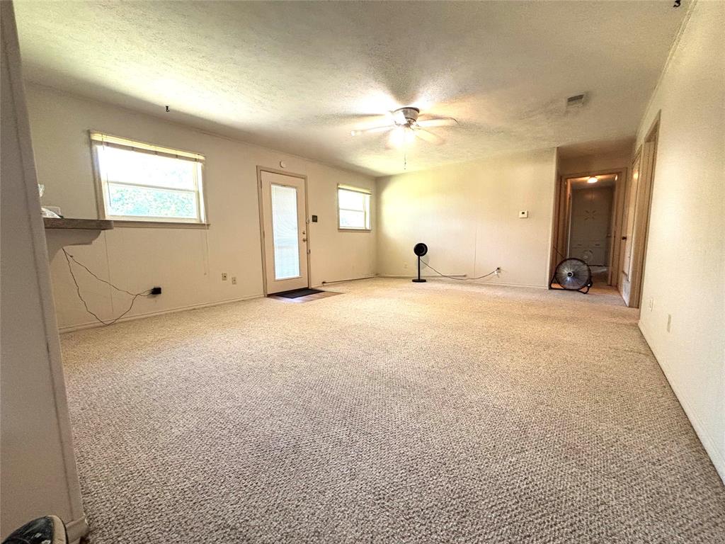 1910 Jefferson Street Commerce, TX 75428 - Photo 12 of 16 an empty room with a ceiling fan and a window