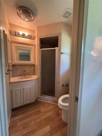 a bathroom with a granite countertop sink toilet and shower