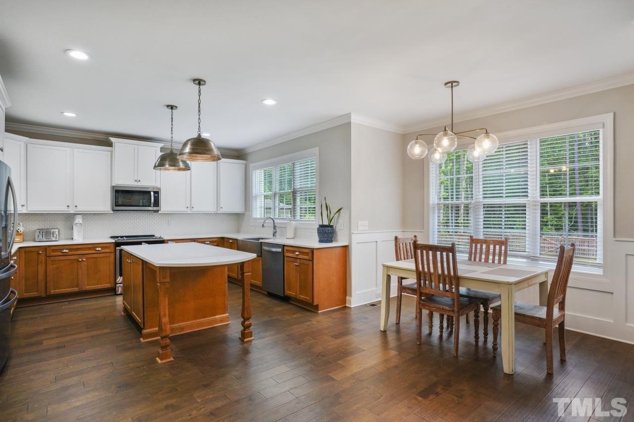 8600 Flannery Court Knightdale, NC 27545 - Photo 9 of 36 a kitchen with stainless steel appliances granite countertop a stove a refrigerator a kitchen island a dining table and chairs