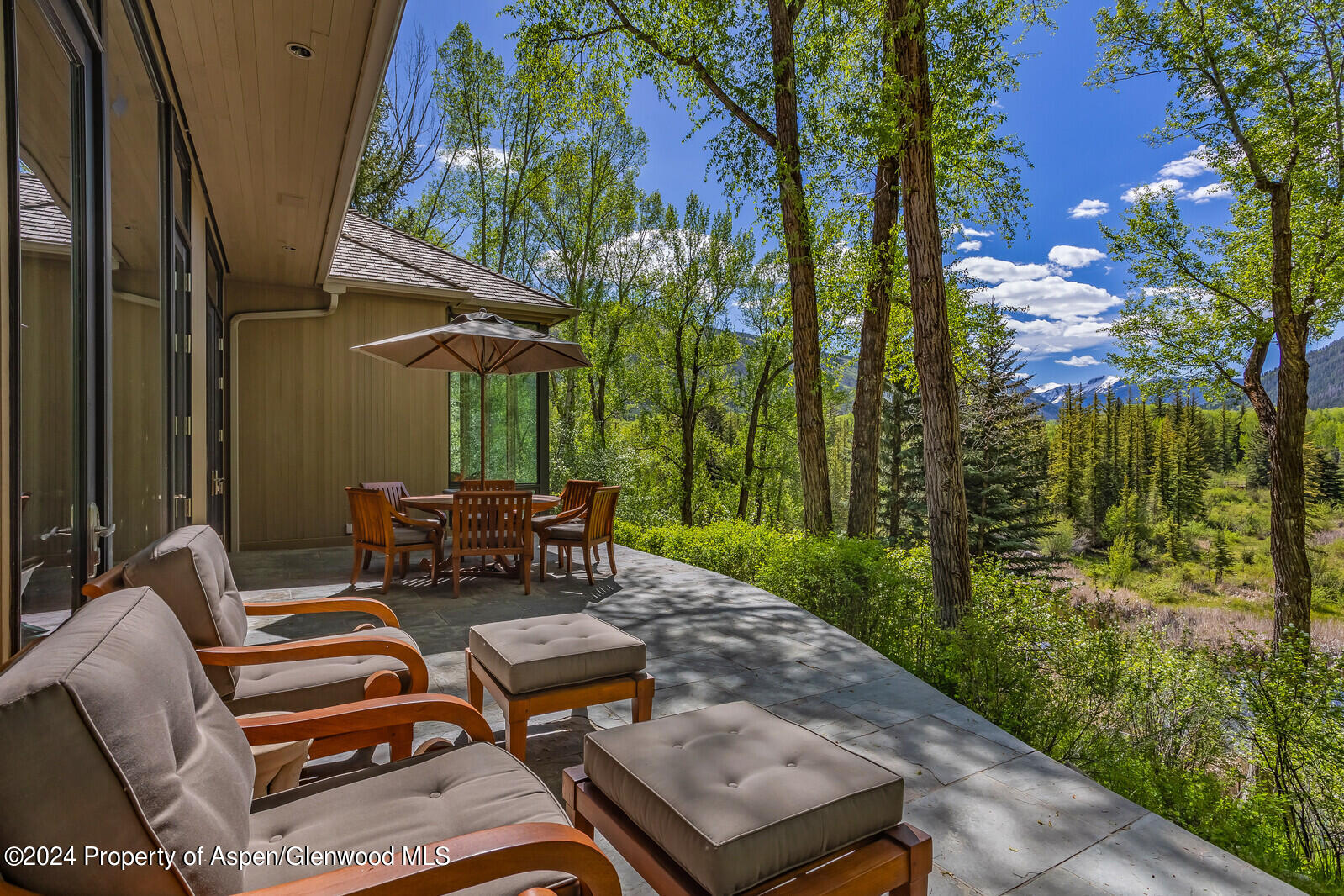 844 Roaring Fork Road Aspen, CO 81611 - Photo 13 of 39 a backyard of a house with table and chairs