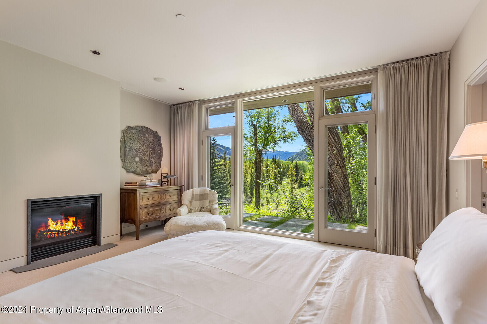 844 Roaring Fork Road Aspen, CO 81611 - Photo 24 of 39 a bedroom with a large bed and a fireplace