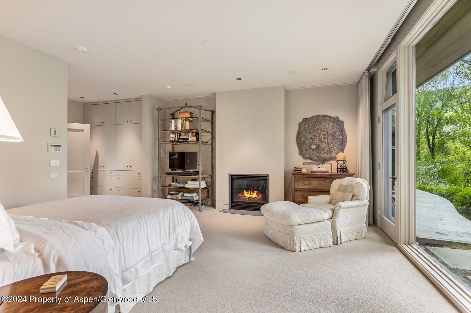 844 Roaring Fork Road Aspen, CO 81611 - Photo 25 of 39 a spacious bedroom with a bed a fireplace and a large window
