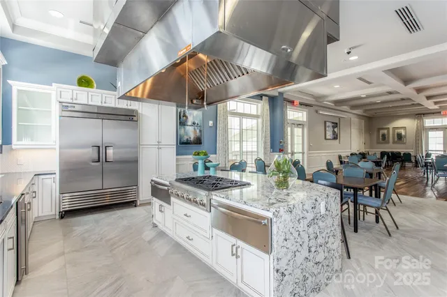 a kitchen with stainless steel appliances granite countertop a stove a sink and a refrigerator
