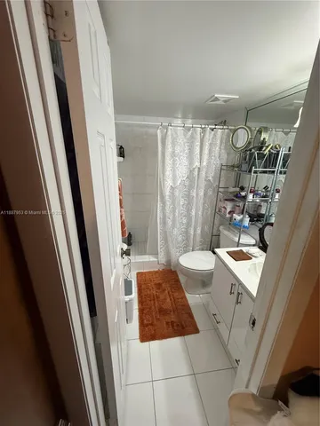 a bathroom with a sink a toilet a mirror and shower