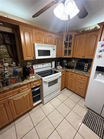 a kitchen with granite countertop a sink stainless steel appliances and cabinets