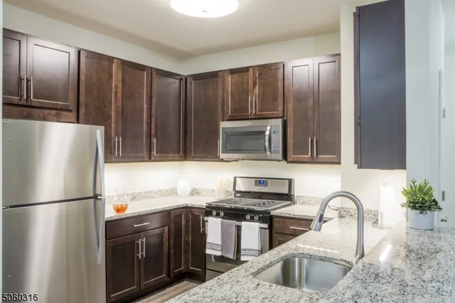 a kitchen with a refrigerator sink and cabinets