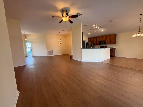 a view of a kitchen with a sink and dishwasher a refrigerator with wooden floor