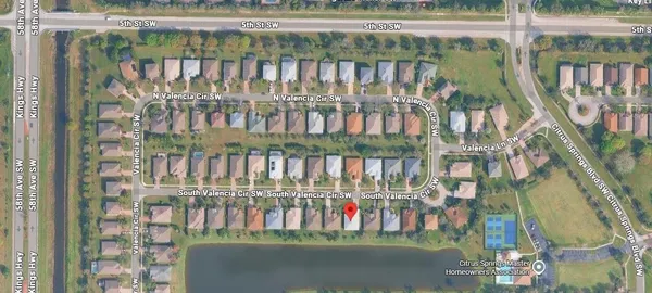 an aerial view of residential houses with outdoor space and lake view