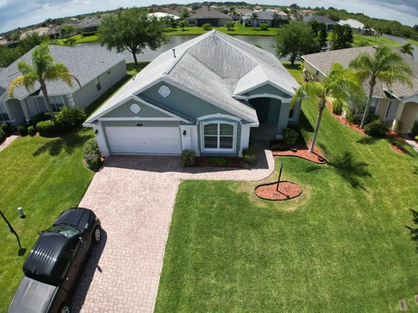 an aerial view of residential houses with outdoor space and lake view