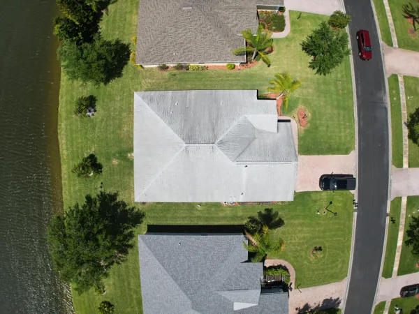 an aerial view of a tennis ground and a cars park side of the road