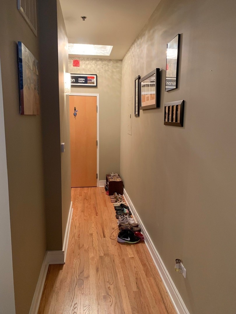 212 West Washington Street, Unit 1106 Chicago, IL 60606 - Photo 14 of 25 a bedroom with a bed and wooden floor