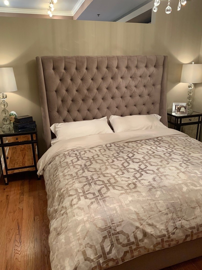 212 West Washington Street, Unit 1106 Chicago, IL 60606 - Photo 21 of 25 a large bed sitting in a bedroom next to a lamp