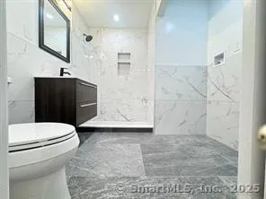 a bathroom with a sink a toilet and shower