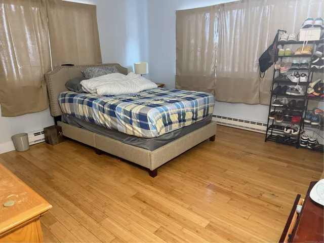 a bedroom with a bed and wooden floor