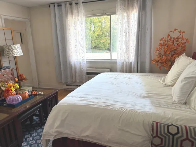 a bed sitting in a bedroom next to a window