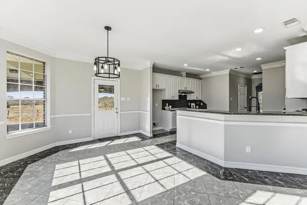 a kitchen with stainless steel appliances kitchen island granite countertop a refrigerator and a sink