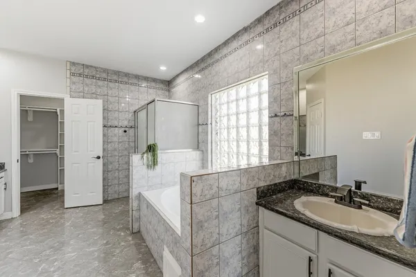 a spacious bathroom with a granite countertop sink and a mirror