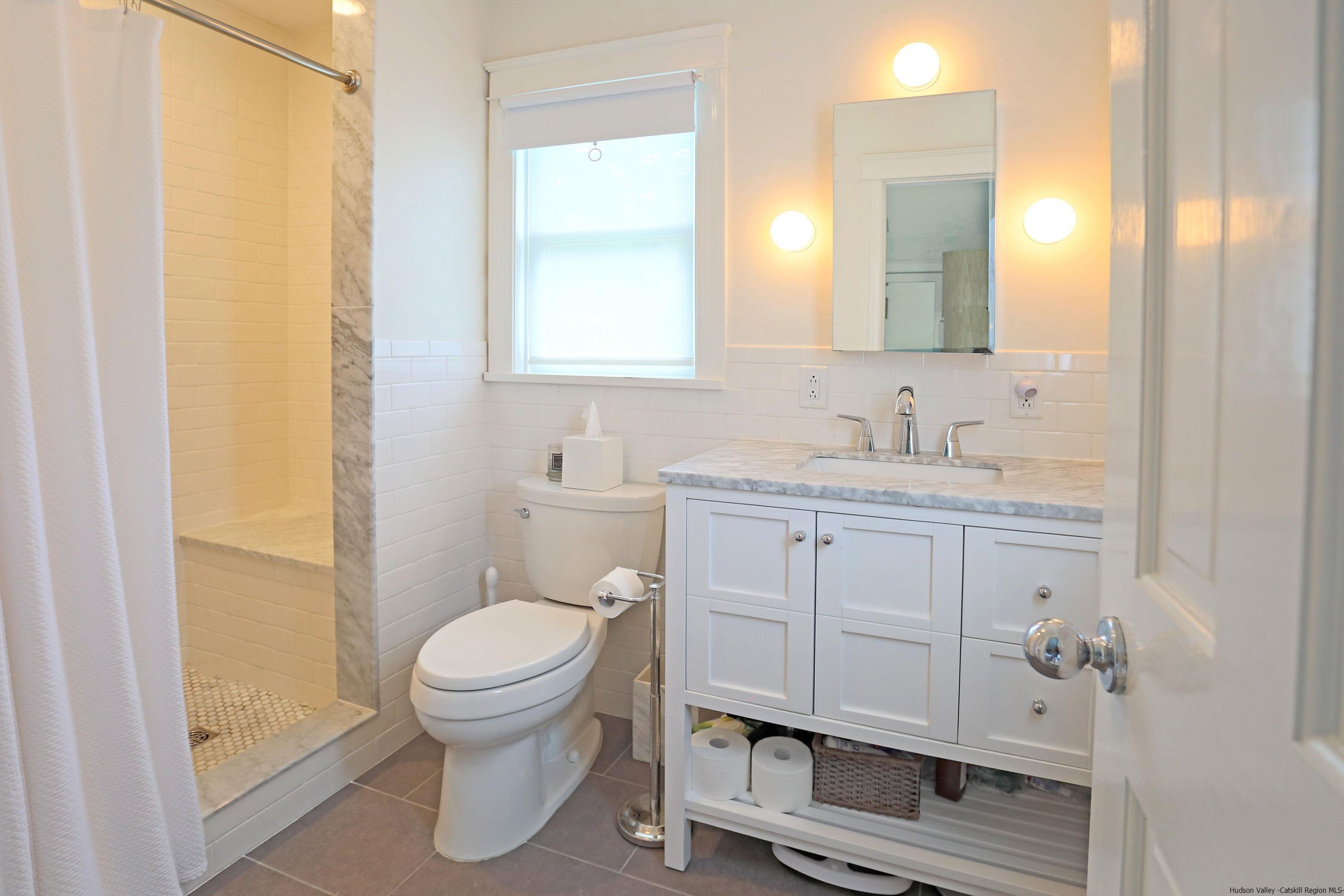 122 Peak Road Stone Ridge, NY 12484 - Photo 13 of 35 a bathroom with a sink a toilet and a mirror