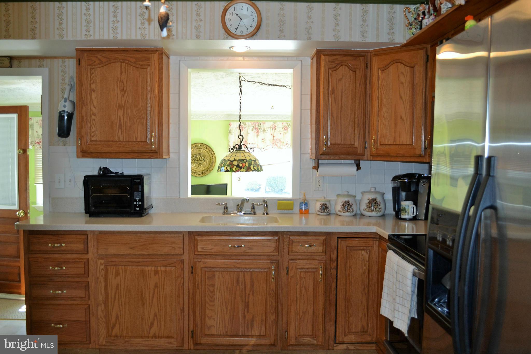 6421 Chell Road Columbia, MD 21044 - Photo 9 of 25 a kitchen with stainless steel appliances granite countertop a sink a stove cabinets and a window